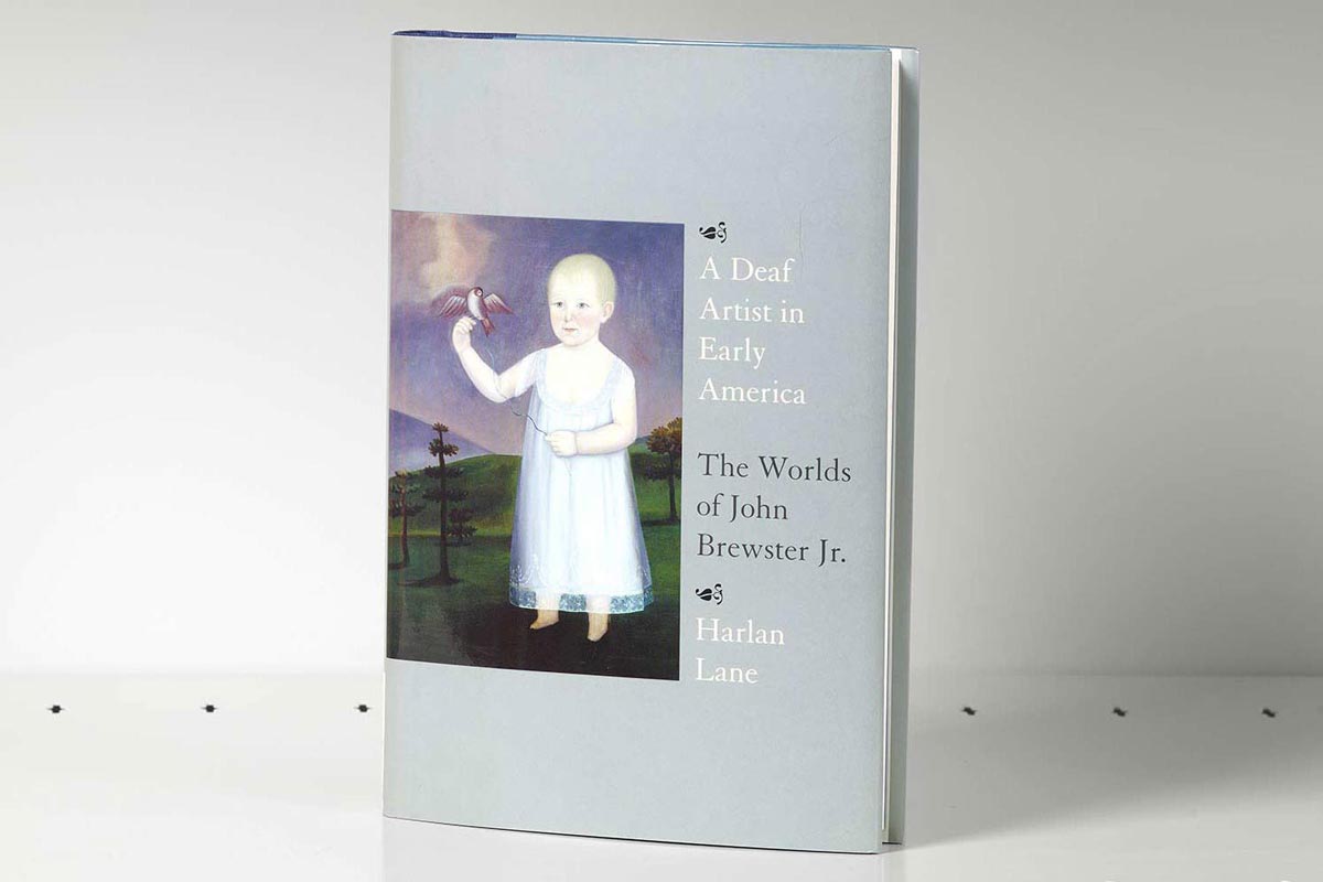 Book on a gray shelf whose cover features an artwork of a young child in a field with a bird on their finger