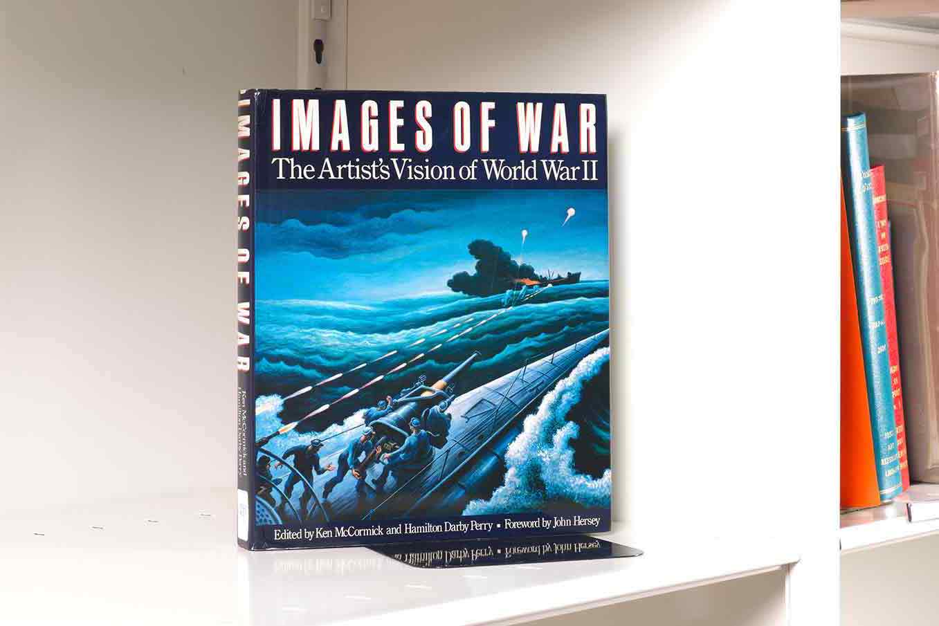 A book cover featuring an artwork detail of battle at sea sitting on a white shelf