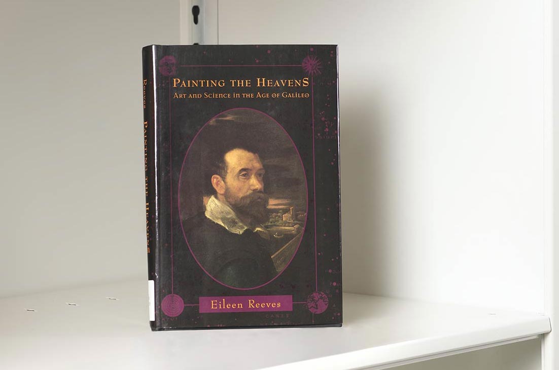 Book on a white shelf whose cover features a painted portrait of Galileo