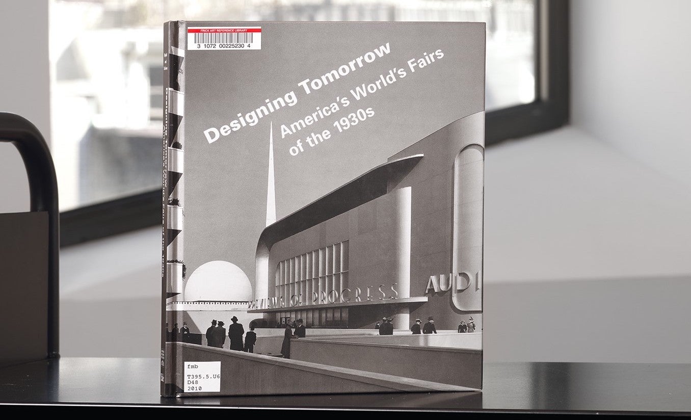 Book with a modern building on its cover on a library cart in front of a window
