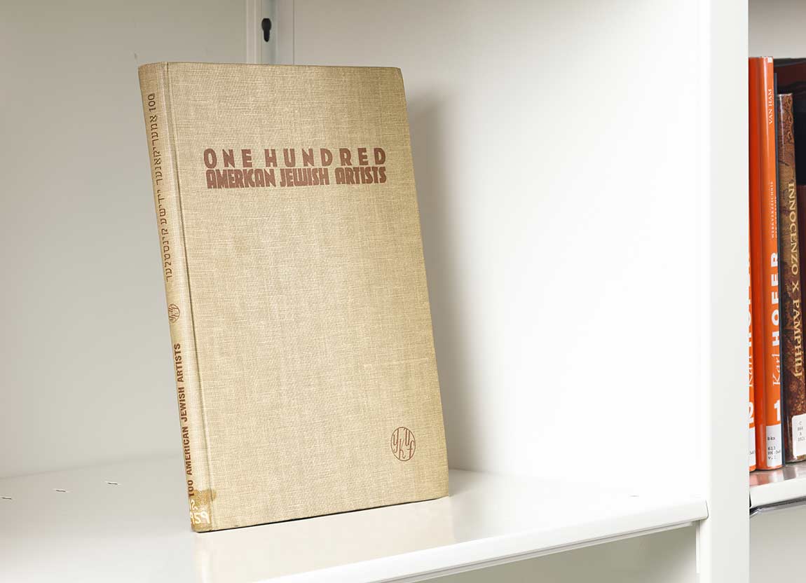 Book on a white shelf whose spine features Yiddish writing