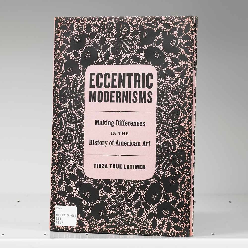 Book on a white shelf whose cover features an abstract black-and-pink pattern