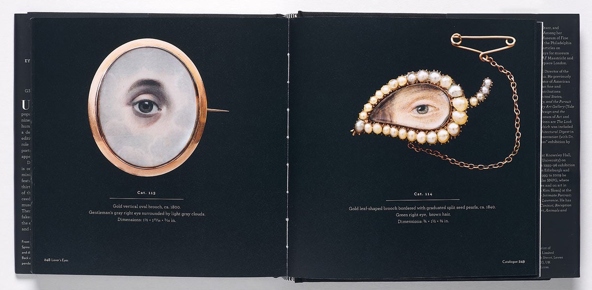 Book spread featuring images of brooches and cameos framing miniature eye portraits