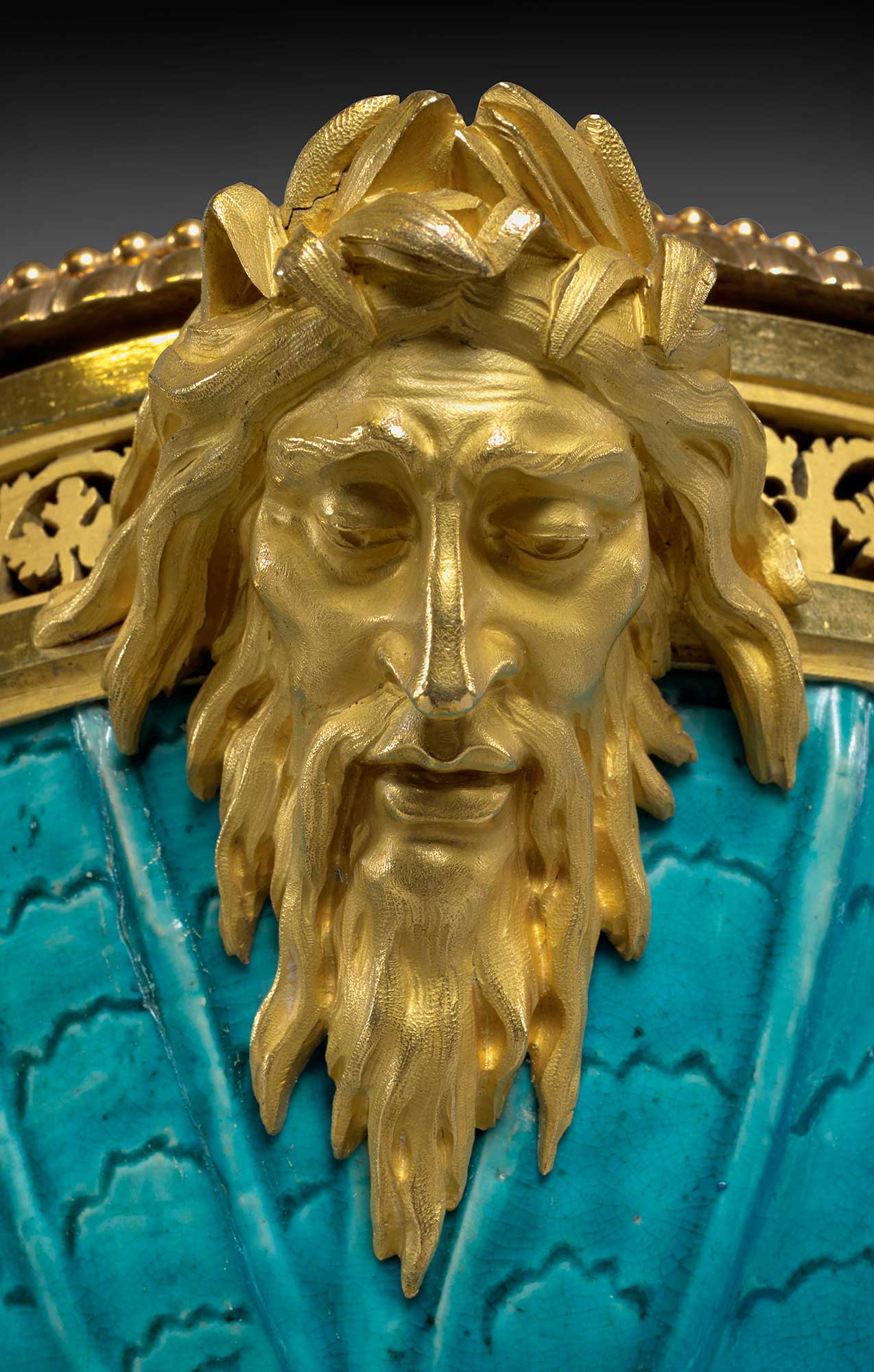 closeup of gilt bronze bearded male, adorning back of porcelain vase