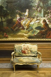 photo of painting above antique small couch in gallery