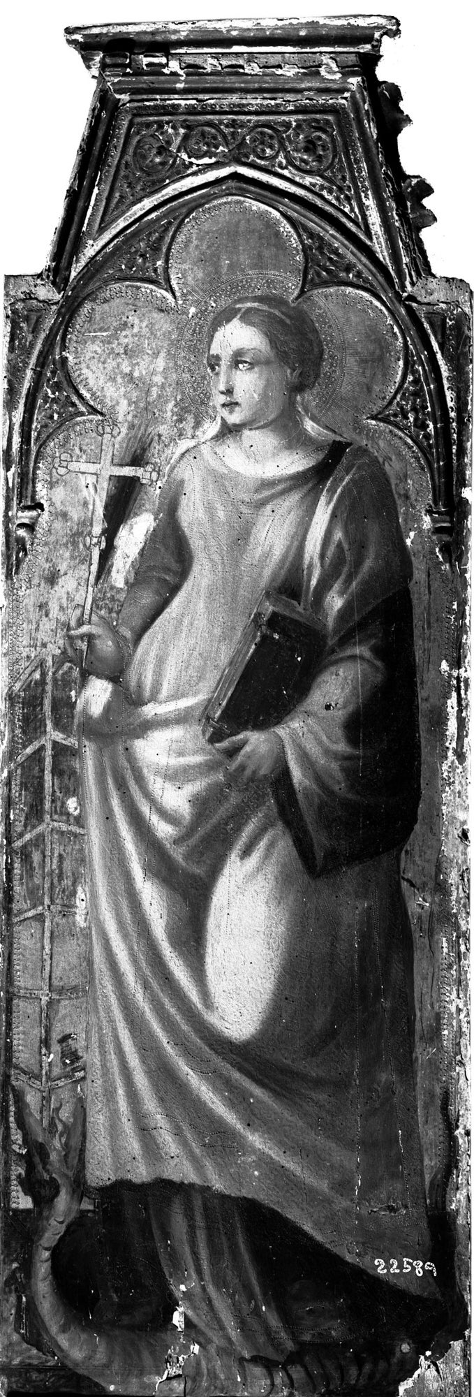 Young woman holding cross and book, facing left and standing on dragon.