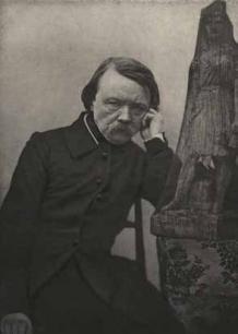 black and white photo of man seated with hand at face