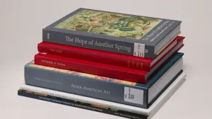 Stack of six books on Asian and Pacific Islander American art history, against a gray background