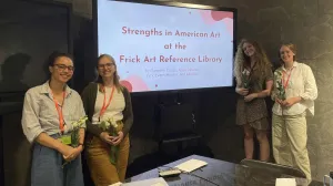 Four interns around a screen reading "Strengths in American Art at the Frick Art Reference Library"