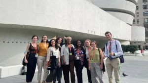 Nine people posing in front of the white Guggenheim Museum building