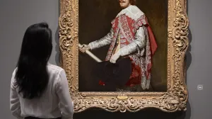 Gallery view of a woman looking at an oil painting of King Philip IV of Spain