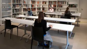 Library users sitting at desks in a reading room