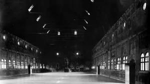 A large room with fifty windows and a ceiling of exposed wooden rafters and beams.