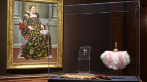 A framed portrait of woman sitting and the marten with a jeweled head and fan