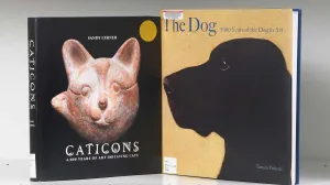 Two book covers on a shelf, one featuring a painting of a dog and the other a sculpture of a cat