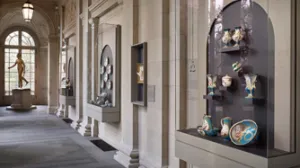 photo of gallery hall with French porcelain behind cabinet