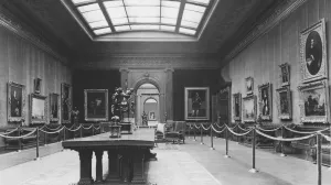 Historical photo of the Frick's West Gallery, 1935, with roped stanchions lining the walls