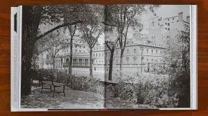Book on a wooden table open to a spread with an image of a mansion on Fifth Avenue