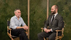 video still of Dan Waterston and Xavier Salomon seated in chairs, talking