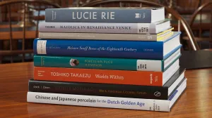 Stack of eight books on a wooden table