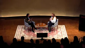 two women sitting on stage in conversation