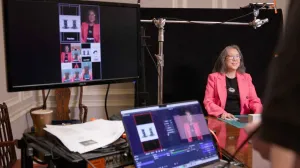 April Kim seated in being filmed and projected on monitors