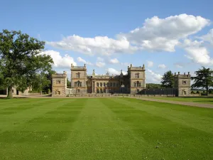 Grimsthorpe castle on great green lawn with blue sky above