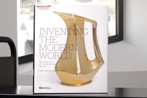 Book with a decorative gold pitcher on its cover on a library cart in front of a window