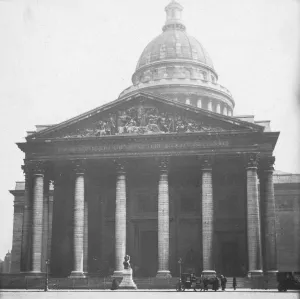 A large classically inspired building with a portico with six columns, a frieze with sculptures, and a dome