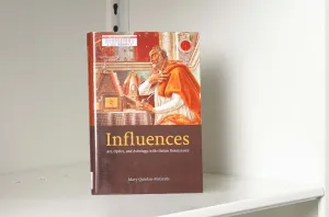 Book on a white shelf whose cover features a painting detail of an ancient astronomer