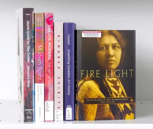 Stack of books with a featured cover showing a sepia photo of a Winnebago woman