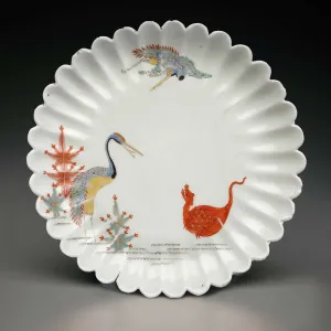 Fluted dish in white porcelain showing two herons and a dragon in various colors of glaze