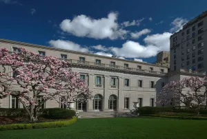 facade of the Frick Collection from Fifth Avenue showing garden and magnolia trees