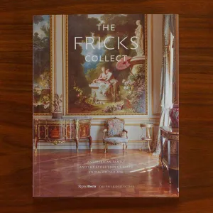 Book on a wooden table whose cover features a museum gallery in a Gilded Age mansion with the title "The Fricks Collect"