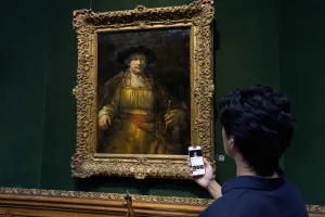 man using mobile guide in front of painting in Frick gallery