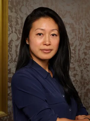 Woman in blue shirt standing in front of a wall
