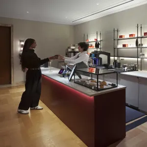 coffee bar at the Frick with patron and clerk exchange of drink