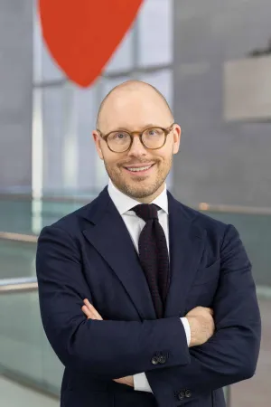Headshot of Dr. Aaron Wile, smiling with glasses in a navy suit
