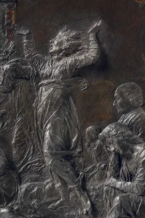 close up of woman wailing on bronze relief 