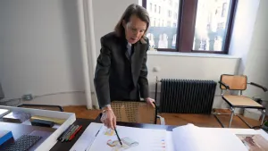 video still of Anna Selldorf over blueprints on table