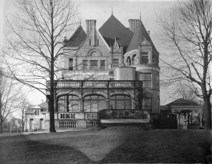 black and white photograph of clayton exterior, a grand mansion with turrets and a sunroom
