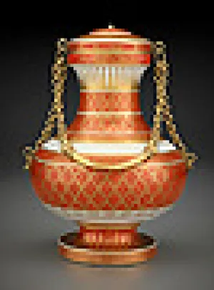 white covered porcelain vase with rust colored diamond pattern and a gold chain