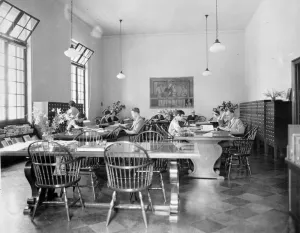 men and women seated at large tables in library, circa 1931-1934