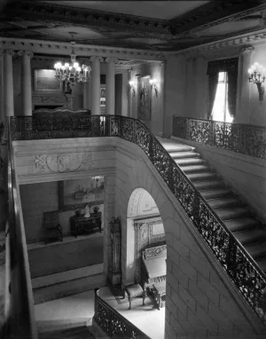 staircase with intricate railing, arch below and organ
